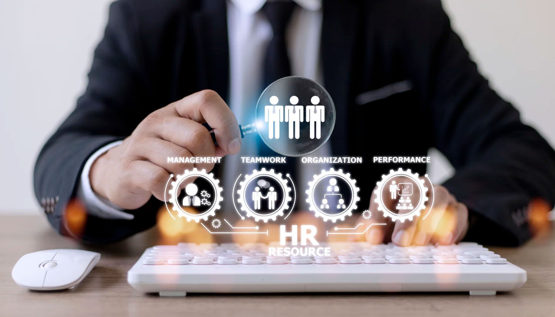 A person is holding a magnifying glass over a keyboard.