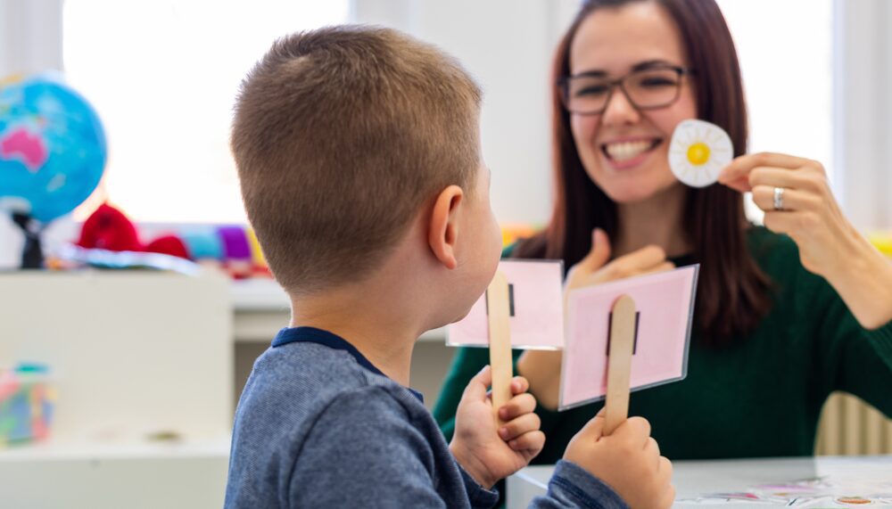 A woman holding two popsicle sticks and a boy.