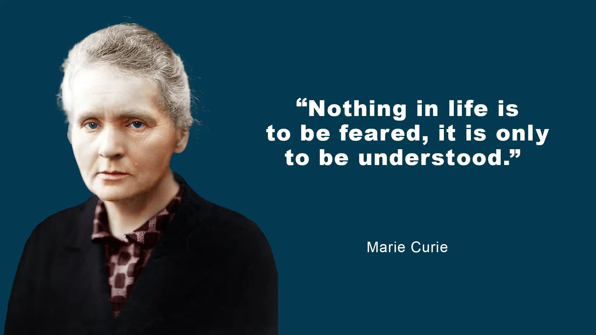 A woman with short hair is standing in front of a blue background.